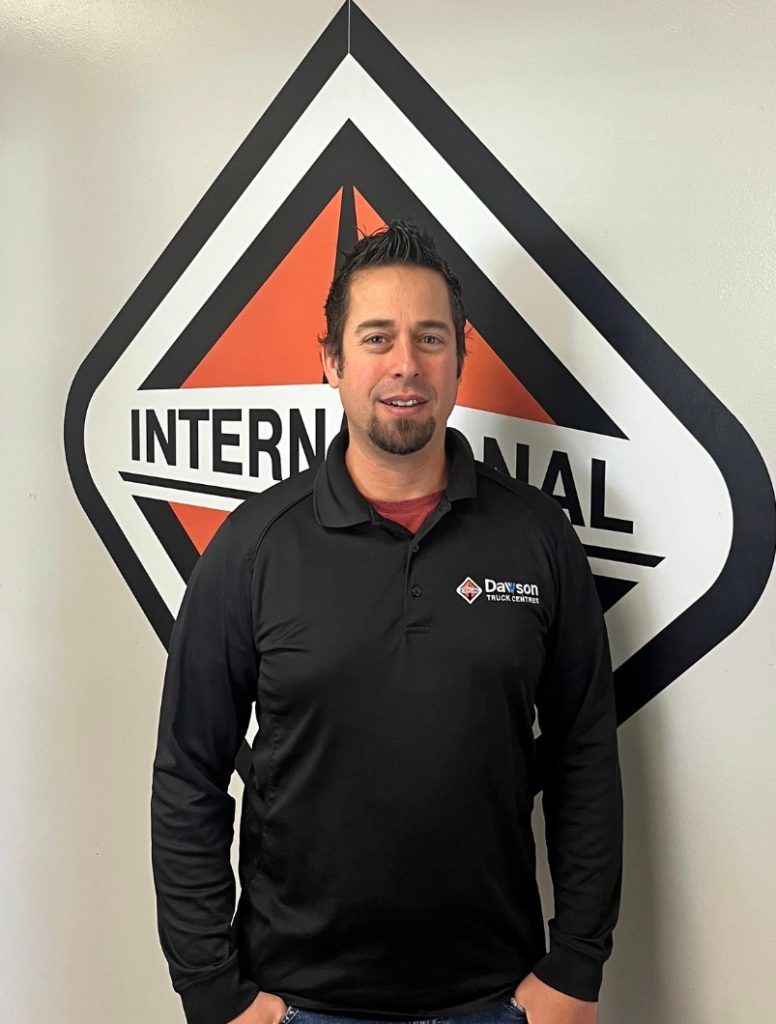 Chad Wager posing in front of the International truck logo