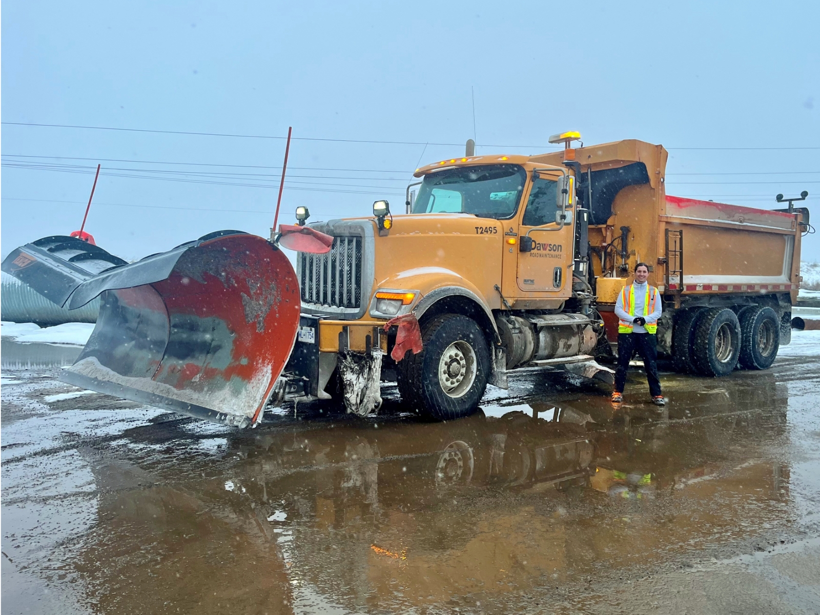 Becca Payette standing beside a heavy-duty plow truck in Fort St. John after earning her Class 3 Licence.